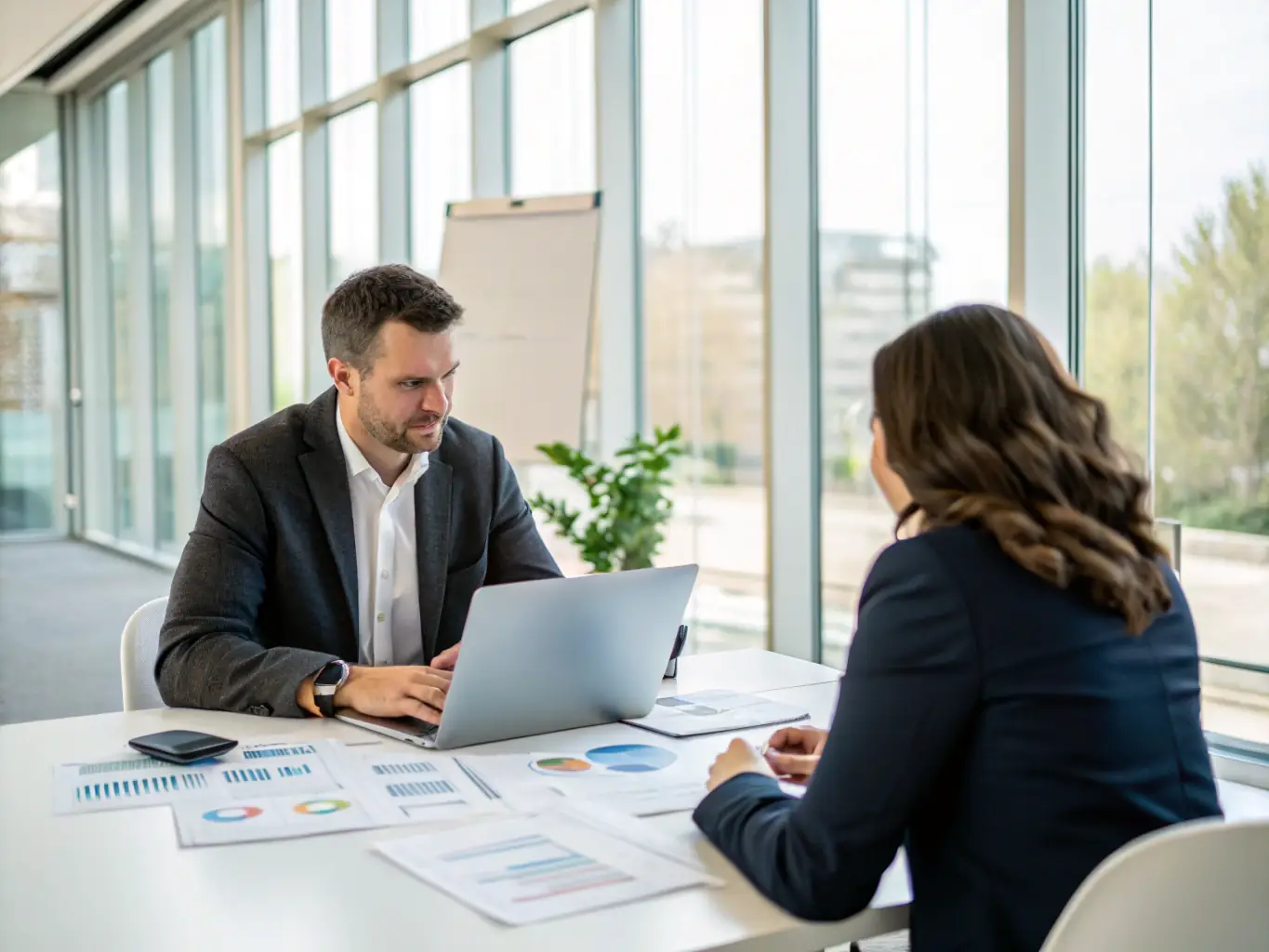 A consultant reviewing business process diagrams with a client in a modern office setting, emphasizing collaboration and strategic planning.